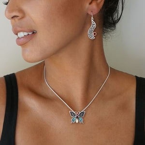 PAUA JEWELRY JEWELED BUTTERFLY NECKLACE WITH GARNET, BLACK MUSSEL, AND FOSSILIZED TUSK